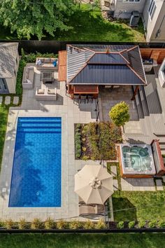 an aerial view of a backyard with a pool and hot tub