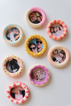 six different colored buttons with photos in them on a white surface and one has an image of two people