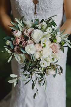 a bride holding a bouquet of white and pink flowers