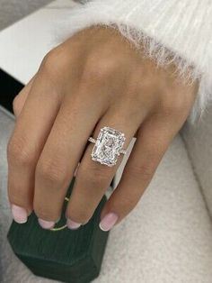 a woman's hand with a diamond ring on it