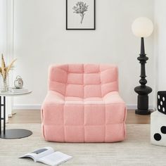 a living room with a pink couch and two black lamps on the side walk way