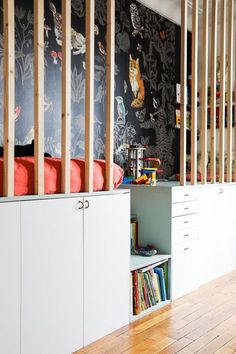 the room is decorated with black and white wallpaper, bookshelves and cabinets