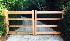 a wooden gate that is next to some bushes