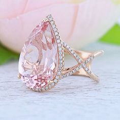 a pink diamond ring sitting on top of a table