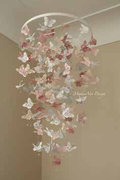 a chandelier with butterflies hanging from it's sides in a room next to a wall