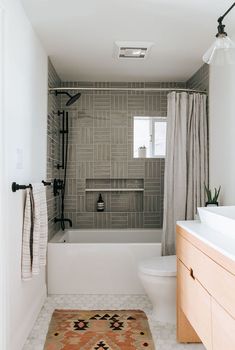 a bathroom with a rug, toilet and bathtub in it's shower stall