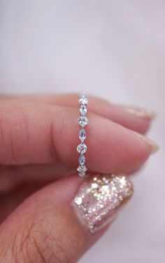 a woman's hand holding a diamond ring