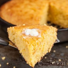 a piece of cornbread is being lifted from a skillet by a spatula