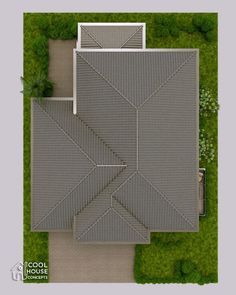 an aerial view of a house with a driveway and grass area in the middle of it