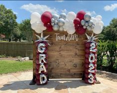 an outdoor sign with balloons and stars on it