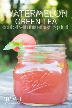 a mason jar filled with watermelon green tea on top of a wooden table