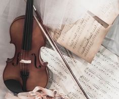 an old violin is laying on sheet music