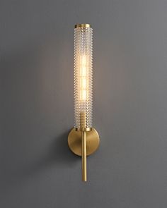 a light that is on the wall with a glass tube in it's corner