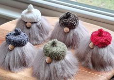 four different types of knitted hair on a wooden board next to a window sill