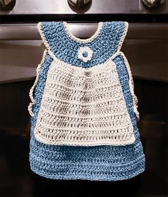 a blue and white crocheted bag hanging from the handle of an oven door