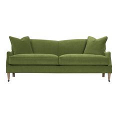 a green couch with two pillows on it