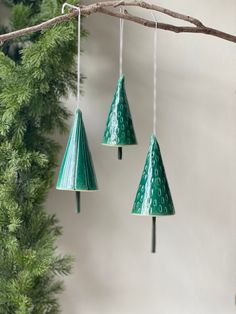 three green plastic cones hanging from a tree branch