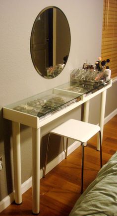 a white vanity table with two mirrors on it and a stool in front of it