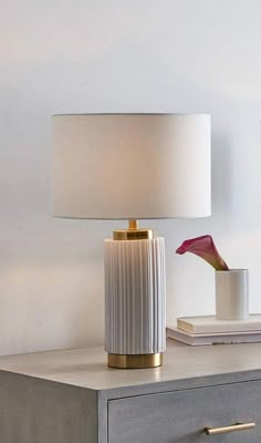 a white lamp sitting on top of a wooden table