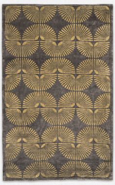 an area rug with gold and grey designs on it, including leaves in the middle