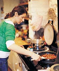 a woman is cooking food on the stove