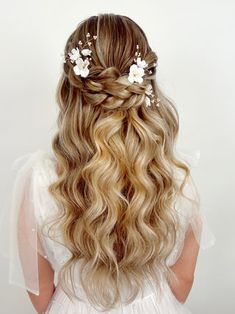 the back of a woman's head with long blonde hair and flowers in her hair