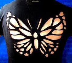 the back of a woman's black shirt with a butterfly cut out on it