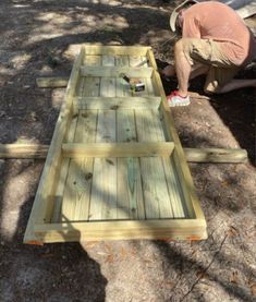 a man working on some wooden boards in the shade with his feet resting on it