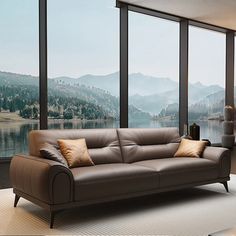 a living room filled with furniture and large windows overlooking a mountain range in the distance