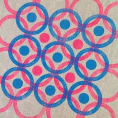 an abstract painting with blue and pink circles on beige fabric, which has been drawn by hand