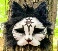 a white and black cat mask hanging on a tree