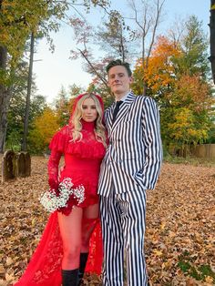 a man and woman dressed up in halloween costumes posing for a photo on the leaves