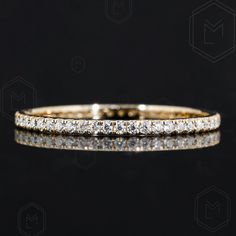 a yellow gold diamond wedding band on a black background