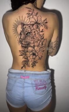 the back of a woman's body with tattoos and flowers on her butts