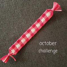 a pink and white crocheted object with words october challenge written on the side