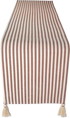 a brown and white striped table cloth with tassels