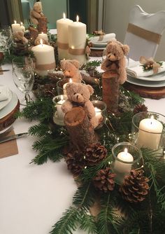 the table is set with pine cones, candles and teddy bears