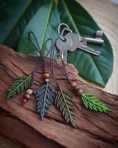 a keychain with beads and leaves attached to it sitting on a piece of wood