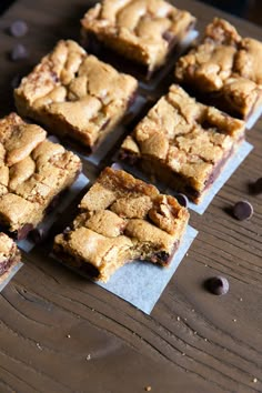 chocolate chip cookie bars sitting on top of a wooden table next to some coffee beans