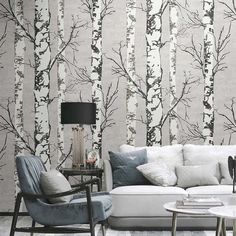 a living room filled with furniture and walls covered in wallpapered birch trees painted on it