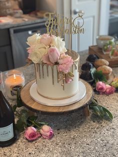 there is a cake with flowers on it and a bottle of wine next to it