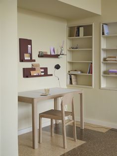 a table and chair in a room with bookshelves