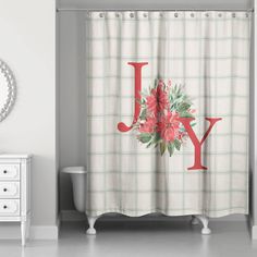 a shower curtain with the letter y on it in red and green floral print, sitting next to a white dresser