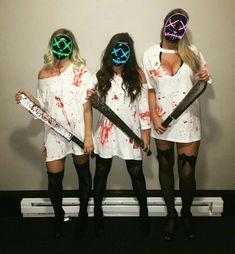 three girls dressed up in costumes with skis and paint on their faces, standing next to each other