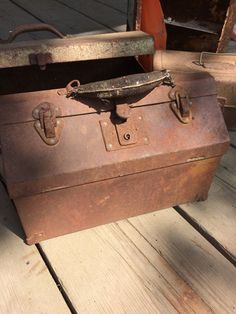 an old suitcase sitting on top of a wooden floor next to another piece of luggage