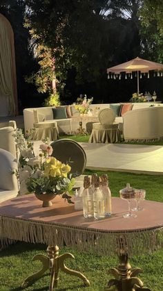 an outdoor setting with tables, chairs and umbrellas in the middle of the grass