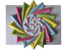 an origami flower made out of colored paper