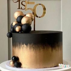 a black and gold cake with the number fifty on top