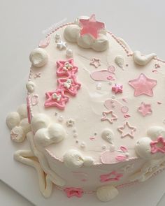 a white cake with pink frosting and stars on it