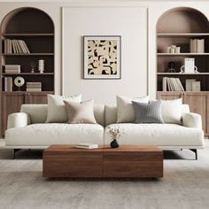 a living room with white couches and bookshelves on the wall behind them